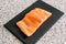 Closeup shot of a delicious piece of salmon a black board