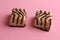 Closeup shot of delicious square biscuits with chocolate cream on a pink background