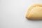 Closeup shot of a delicious typical meat empanada on a white background