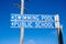 Closeup shot of directional street signs of a swimming pool and public school against a blue sky