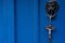 Closeup shot of a door knocker with a wooden religious crucifix