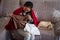 Closeup shot of an East Asian woman opening a package, looking to the cloth in it on the sofa