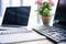 closeup shot of empty textbook, laptop, flowers in pot, computer, computer keyboard and computer mouse