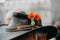 Closeup shot of a fancy cowboy hat with an orange flower on it worn by an elderly person