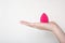 Closeup shot of female hand holding pink beauty blender over a white background. Space for text