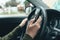 Closeup shot of female hand typing message on smartphone device, casual woman driver wearing green knitted sweater using mobile