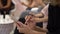 Closeup shot of female hands holding smartphone, typing text on touch screen. Women sit at a conference with phones