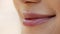Closeup shot of female lips smiling over beige background