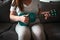 Closeup shot of a female playing a green ukulele