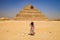 Closeup shot of a female standing in front of a Pyramid in Egypt