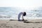 Closeup shot of a female in white stretching in a beach