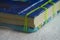 Closeup shot of folded paper sheets bound with green thread