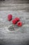 Closeup shot of four raspberries on a wooden surface