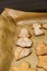 Closeup shot of fresh sweet gingerbread in different shapes on baking paper in soft focus