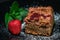 Closeup shot of a freshly baked cake with raspberries, jostaberries and rhubarb on a black plate isolated on black background with