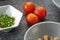 Closeup shot of freshly washed tomatoes and a bowl of cut scallions