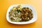 Closeup shot of fried rice, Chinese noodles with chicken, veggies isolated on a yellow background