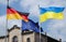 Closeup shot of Germany, Ukraine, and EU flags fluttering on a  sky background