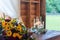 Closeup shot of glass candleholders and a bouquet of flowers on a wooden table