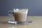 Closeup shot of a glass of half-drunk cinnamon chai latte on a wooden surface