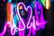 Closeup shot of a glowing purple neon heartbeat sign with a blurred background
