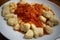 Closeup shot of gnocchi and tomato sauce on a plate