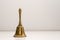 Closeup shot of a golden handbell on a white wall background