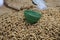 Closeup shot of a green bowl on a pile of beans