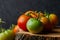 Closeup shot of green and red tomatoes on a tree stump on a black background