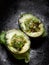 Closeup shot of grilled avocado halves staffed with finely chopped onion, tomatoes and greens