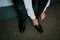 Closeup shot of a groom tying his shoes on the wedding day