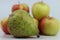 Closeup shot of a group of apples and a pear on a white background.