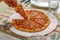 Closeup shot of a hand of a person taking one slice of delicious pizza