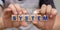 Closeup shot of hands catching wood block with system word computer light design