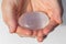 Closeup shot of hands holding a beautiful smooth rose quartz round stone