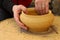 Closeup shot of the hands of a potter creating a jar