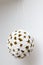 Closeup shot of a hanging gold and white rose bouquet ball pinata with white background