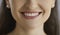 Closeup shot of a happy young woman's smile with perfect white even healthy teeth