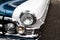 Closeup shot of headlamps of a white and blue retro car