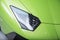 Closeup shot of a headlight of a green car