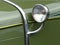 Closeup shot of a headlight of a green vintage car
