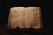 Closeup shot of a historic old Bible open on the Haggai pages on display in a dark room