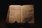 Closeup shot of a historic old Bible open on the Hebrews pages on display in a dark room
