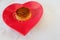 Closeup shot of a homemade flan pudding on a red heart-shaped plate