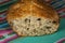 Closeup shot of homemade loaf bread with seeds on a colourful cloth
