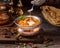 Closeup shot of an Indian buttered chicken dish in a bowl on a wooden board