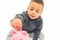 Closeup shot of an innocent curious baby saving his coins using pink piggy bank over white background. Studio shot.