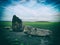 Closeup shot of irregular rough rocks with a fresh lawn field behind under a beautiful cloudscape