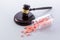 Closeup shot of the judge\'s gavel and pills falling from jar - concept of illegal sale of medicines