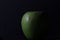 Closeup shot of a juicy apple with waterdrops isolated on a black background